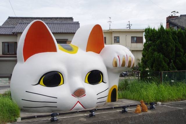 Um Maneki Neko gigante vigia esta cidade japonesa